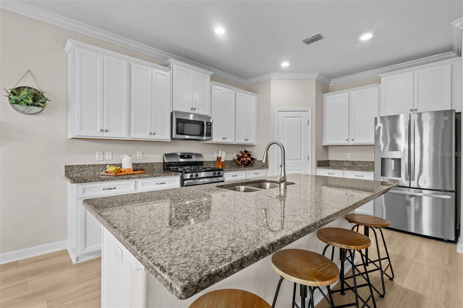 Stylish kitchen with white cabinetry and granite counters.