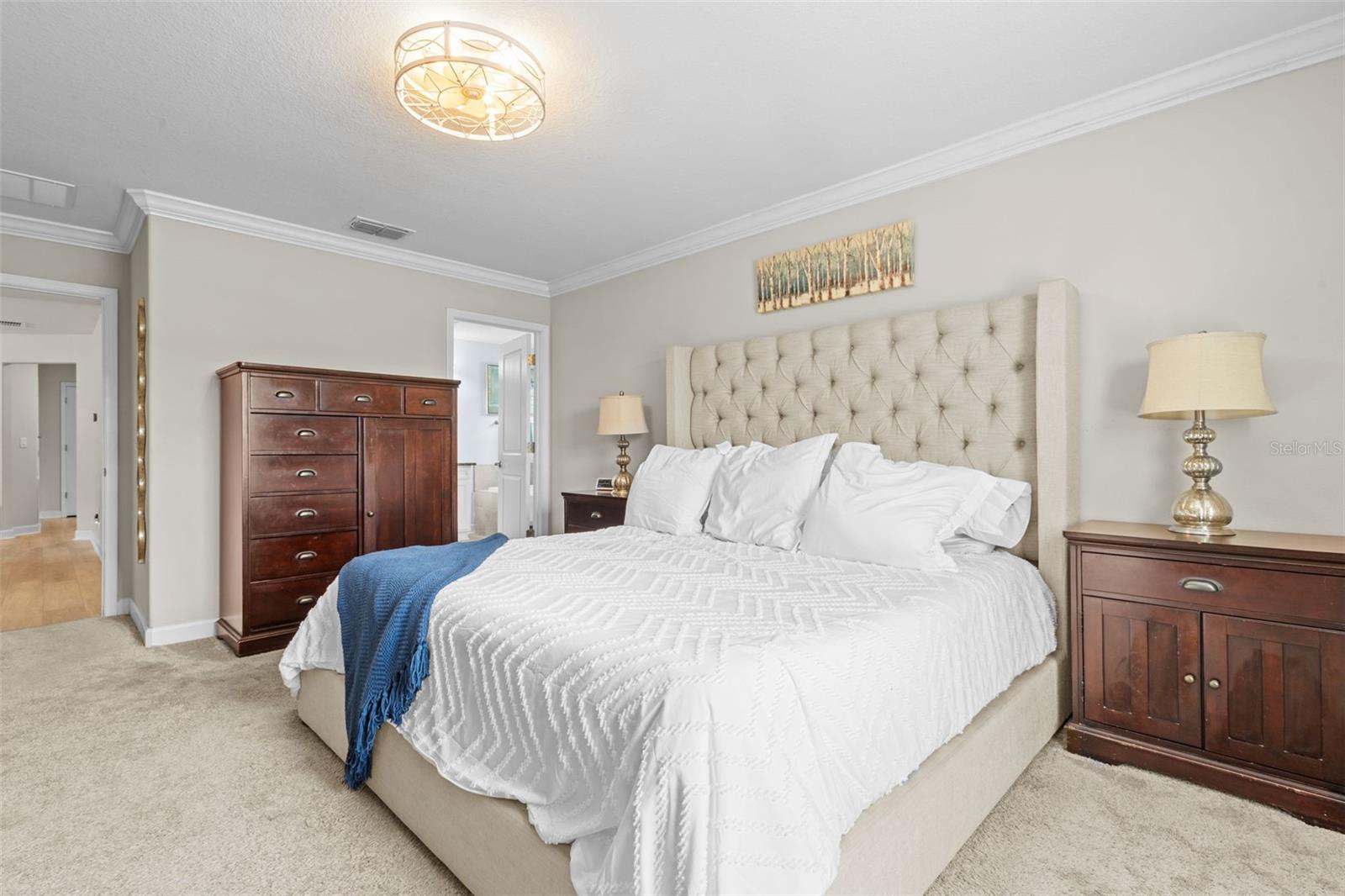Spacious primary suite with crown molding and en suite bath.