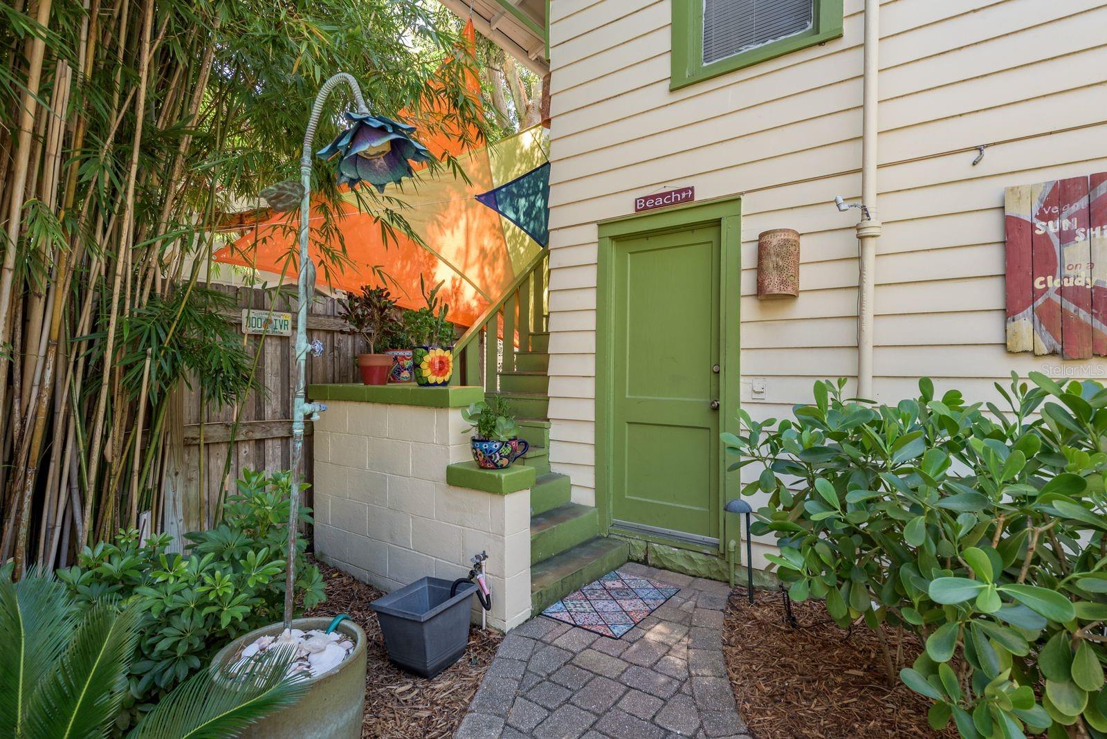 OUTDOOR SHOWER, ENTRANCE TO GARAGE, LAUNDRY AND STAIRS TO ADU