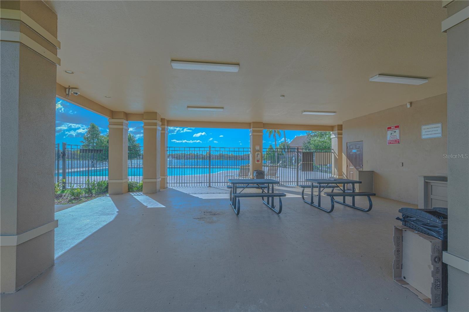 Picnic tables and BBQ station by the pool.