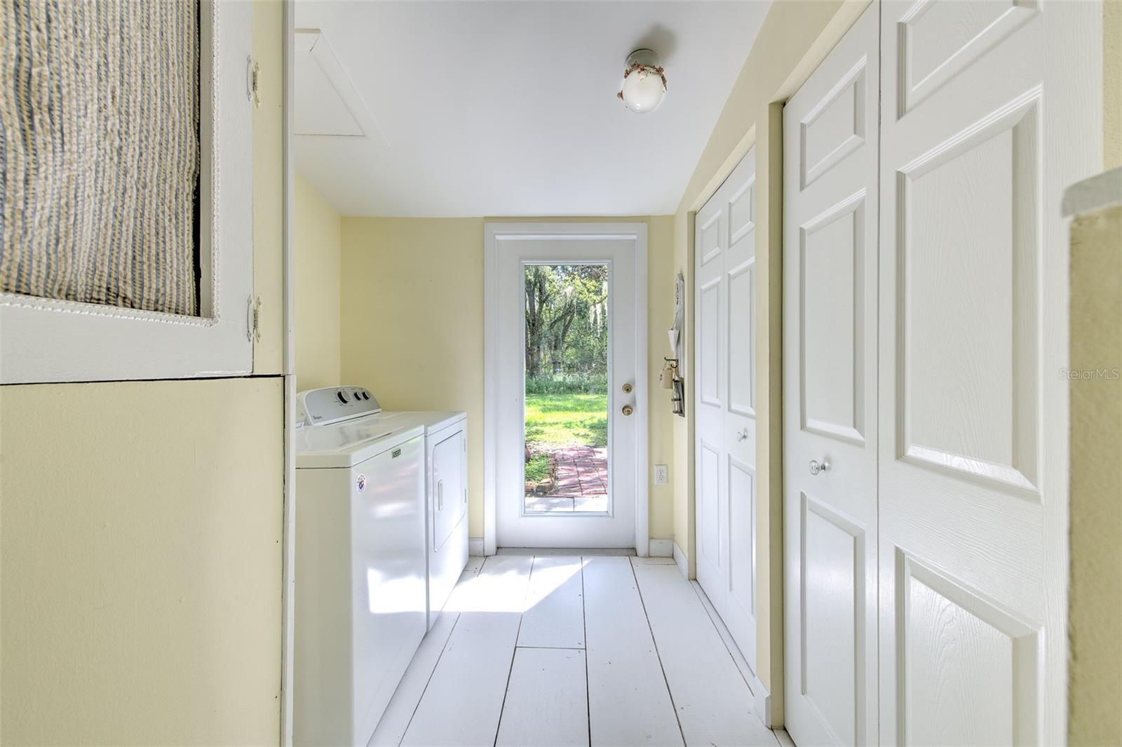 Laundry room located off bonus room with large built-in storge closet and glass door to backyard