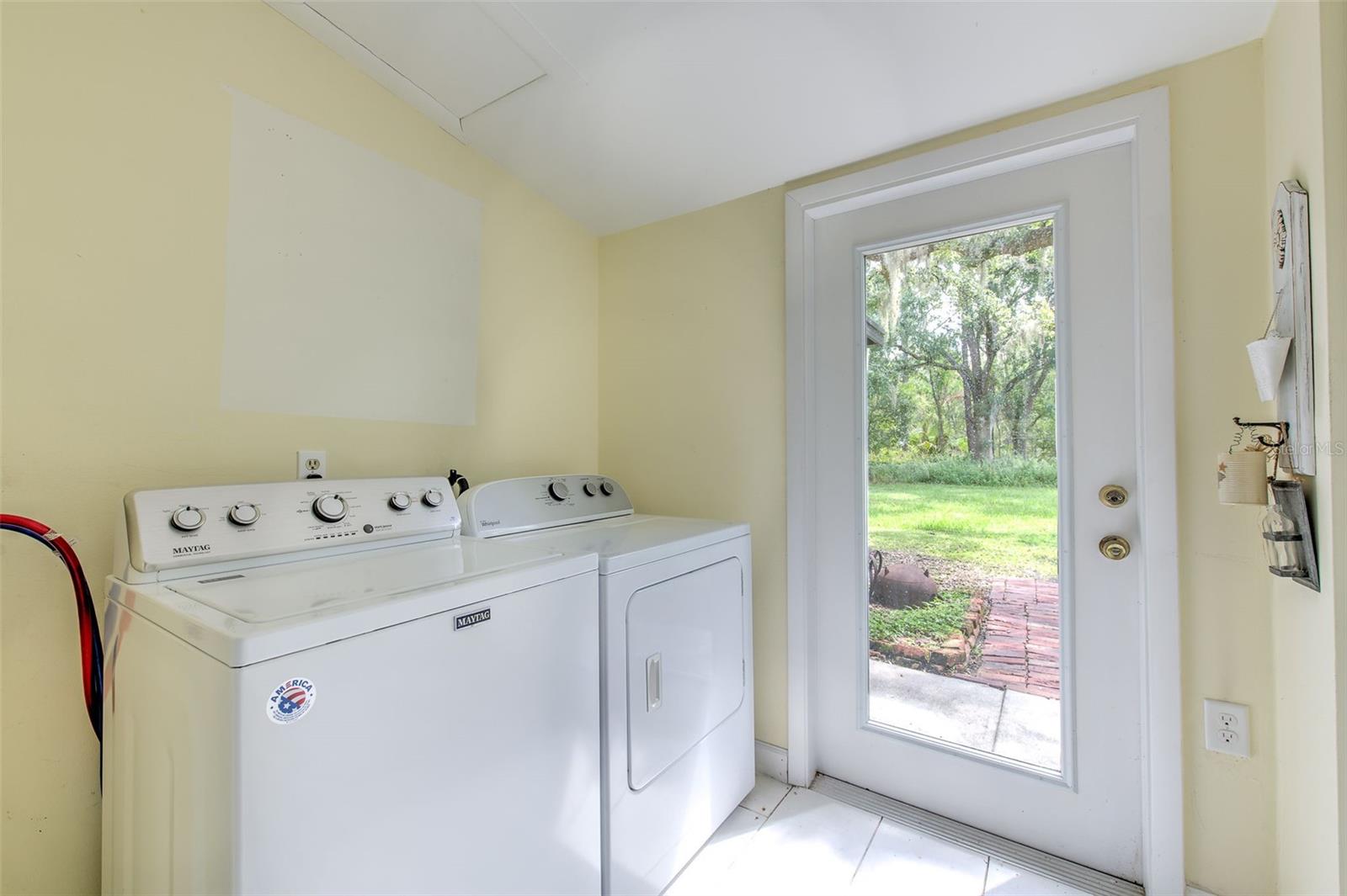Laundry room located off bonus room with large built-in storge closet and glass door to backyard