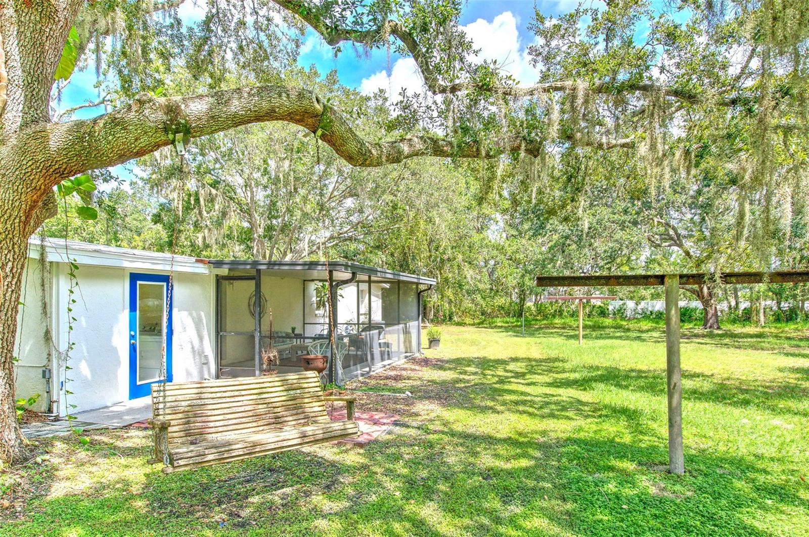View of swing & screened-in patio from backyard