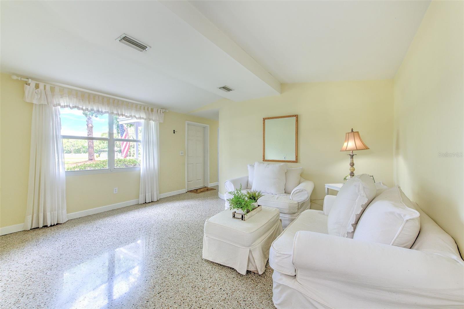 View of open living room with sunny view of the font entrance