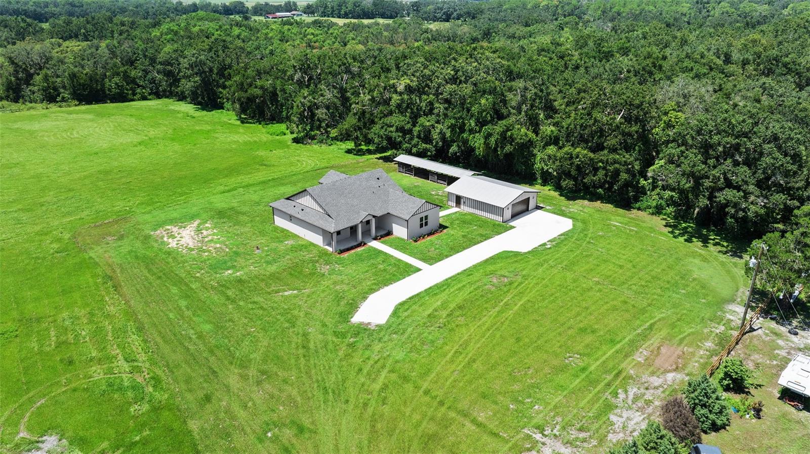 aerial view showing view entering from driveway and north side tree line