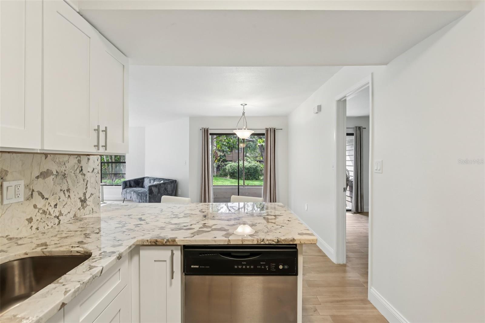 Large slider in dining area streams light into kitchen.