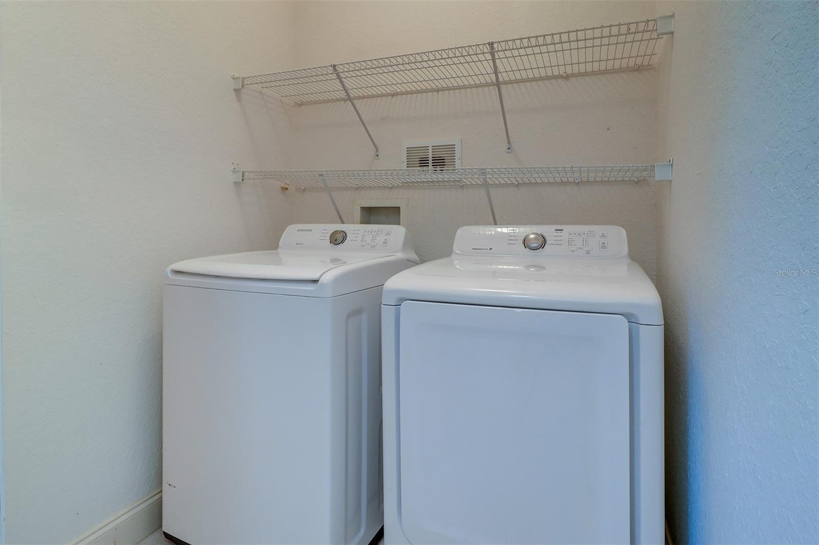 Utility room with full size washer and dryer and shelving