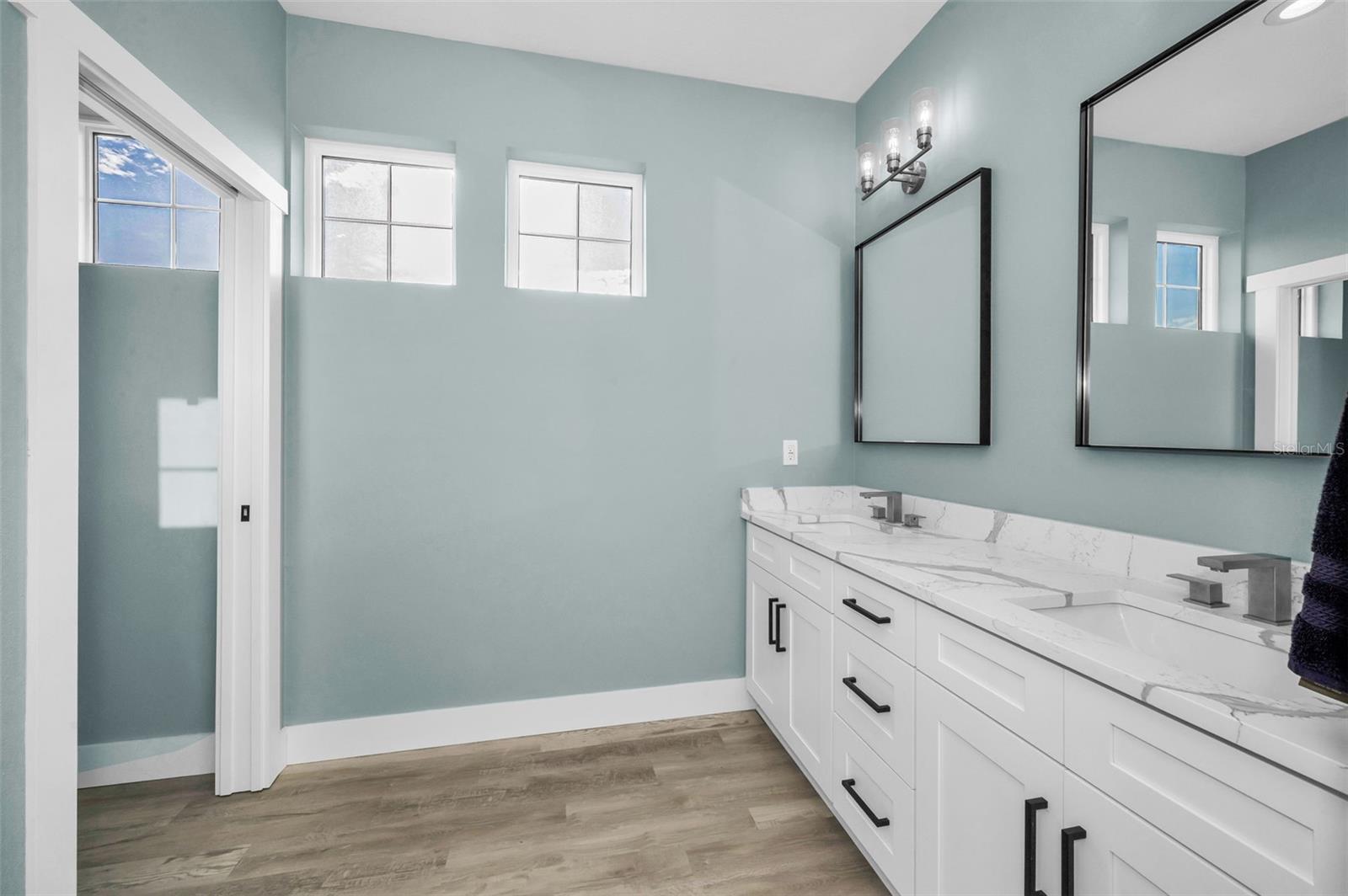 Upper level bathroom with double sinks and quartz counters