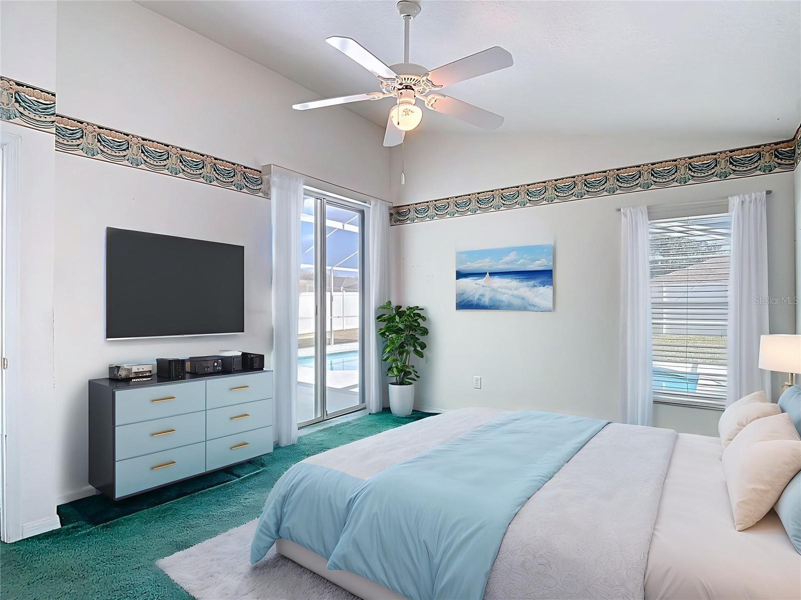 Primary bedroom with slider access to lanai and pool