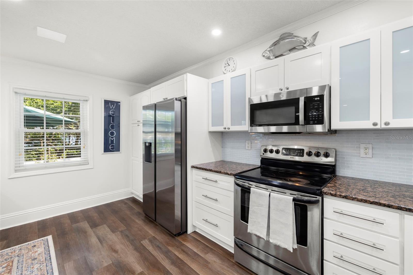 Granite countertops * Glass tile backsplash - Newer stainless steel refrigerator, dishwasher & microwave