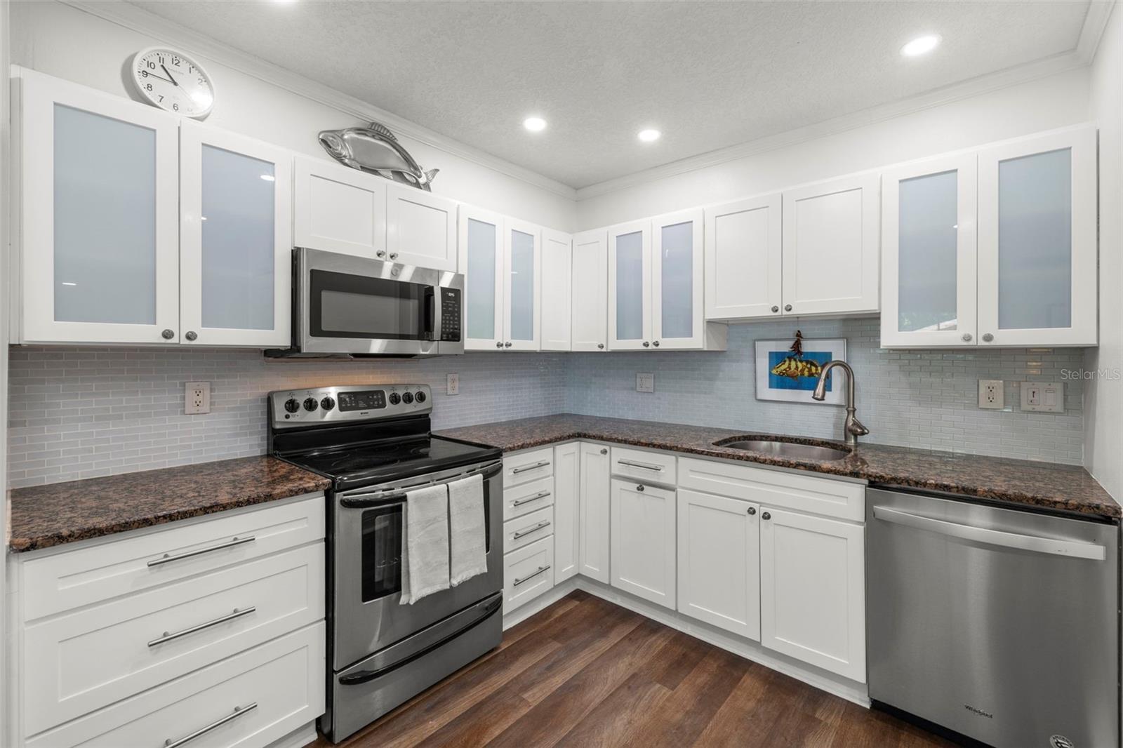 Granite countertops * Glass tile backsplash - Newer stainless steel refrigerator, dishwasher & microwave