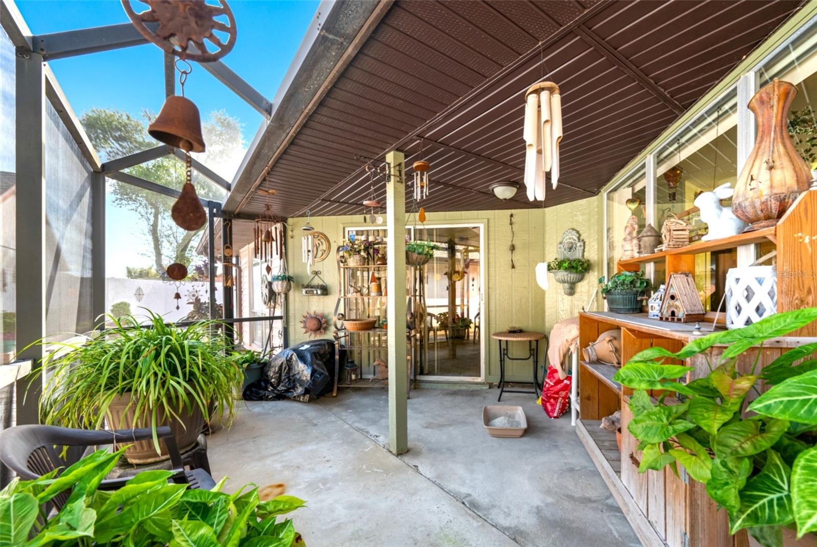 The screened-in patio retreat offers a perfect blend of indoor comfort and outdoor living with a partially covered roof for shade and protection