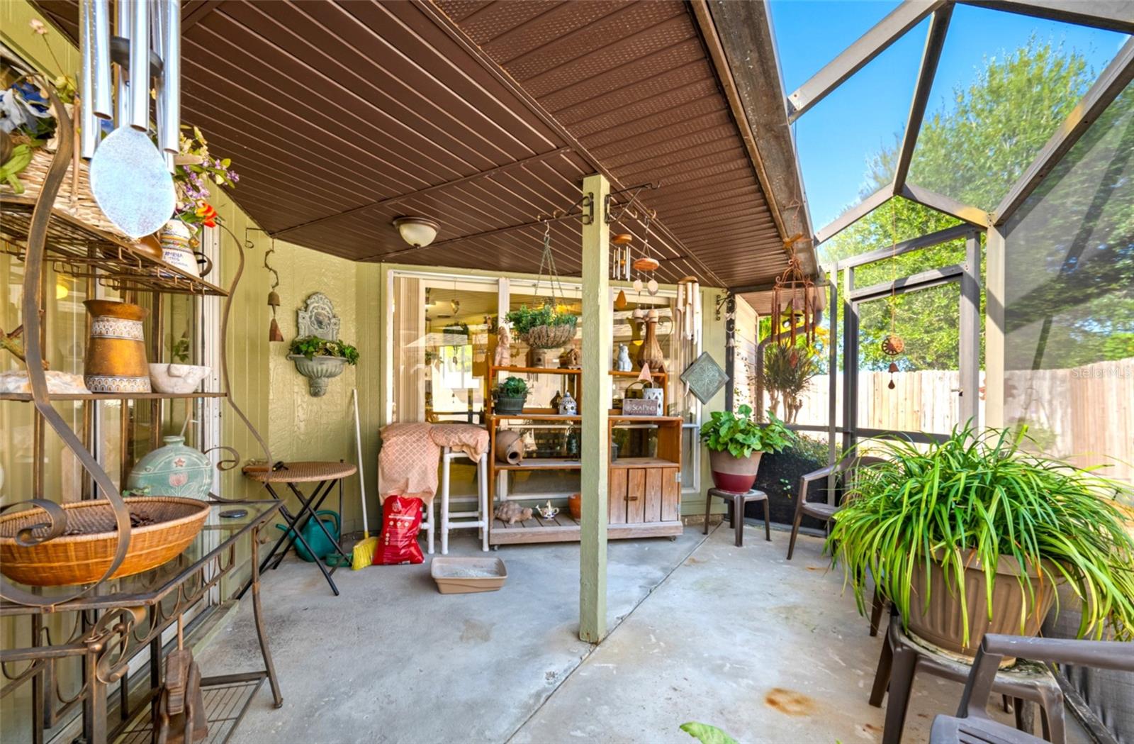 The screened-in patio retreat offers a perfect blend of indoor comfort and outdoor living with a partially covered roof for shade and protection