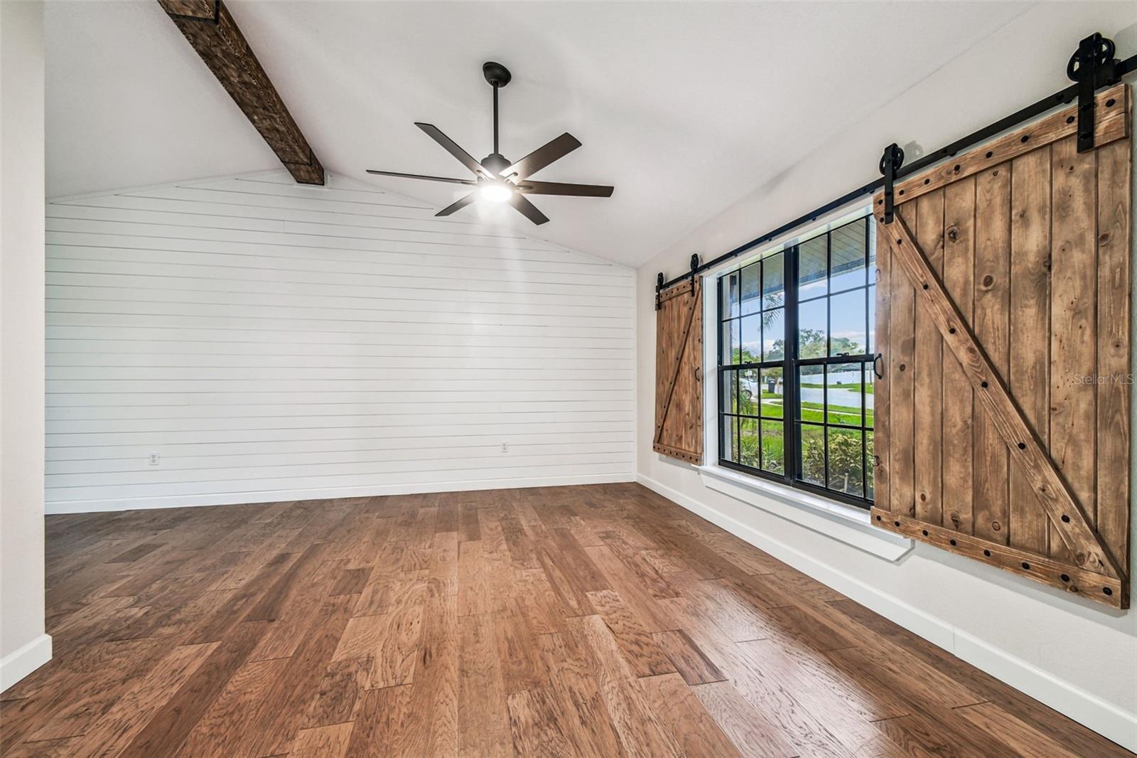 Living room with barn style window treatments and shiplap detail on the walls