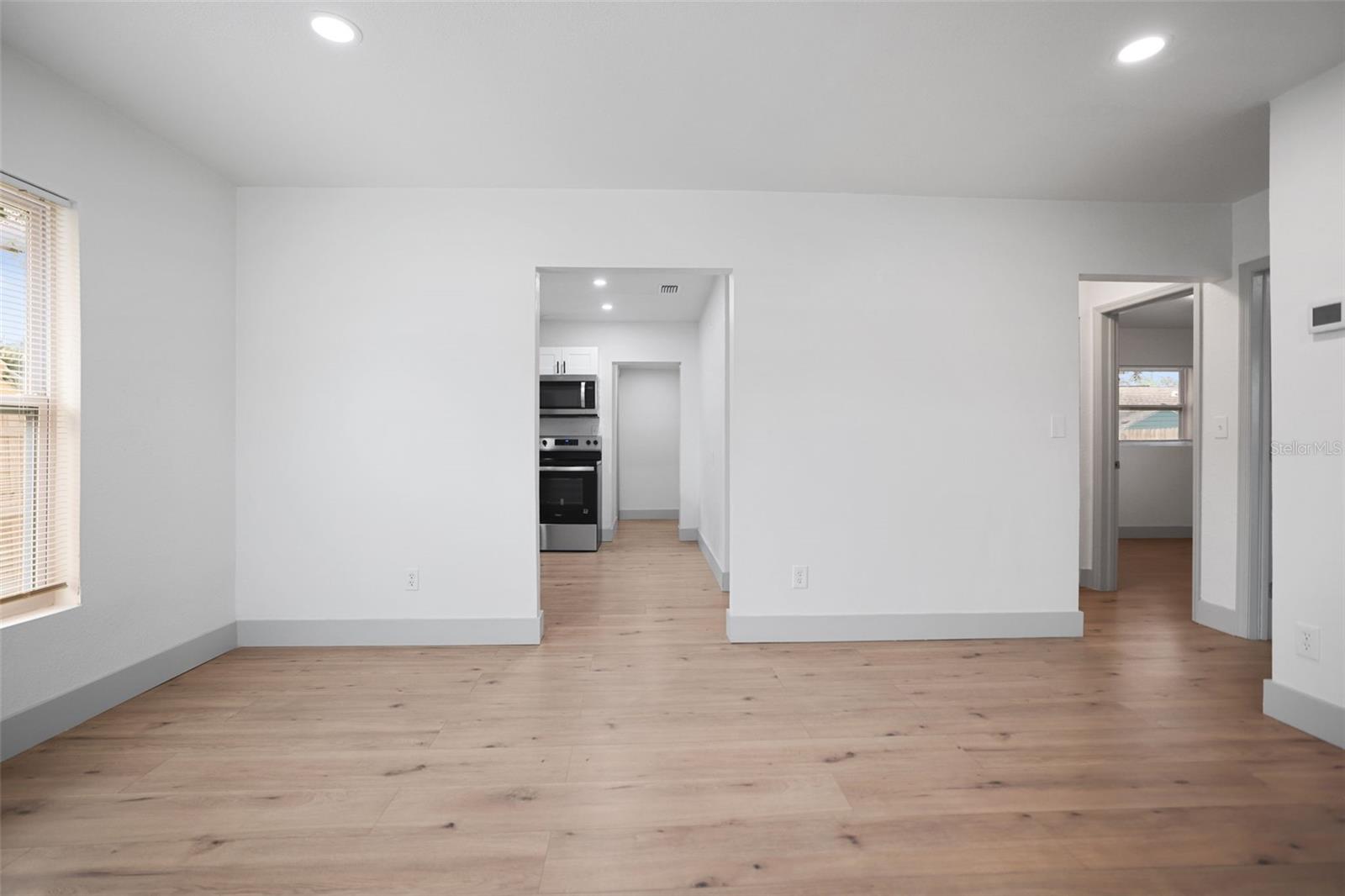 Living room with view of kitchen and hallway to bedrooms