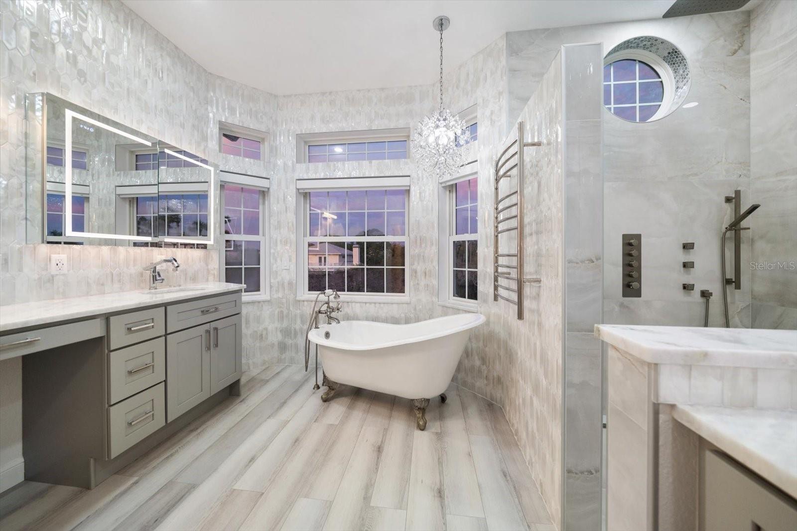 Exceptional remodeled primary suite enhanced with smart features, remote controlled toilet/bidet, touch activated mirrors, soaking tub, and walk-in shower with multiple heads.