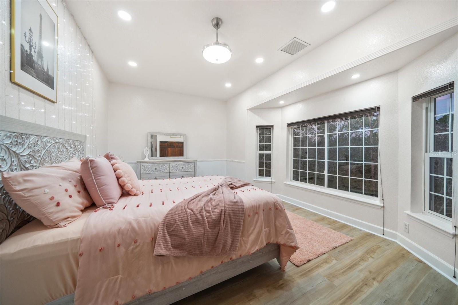 Large second guest bedroom on the east side of the home offers bay windows for a beautiful sunrise.