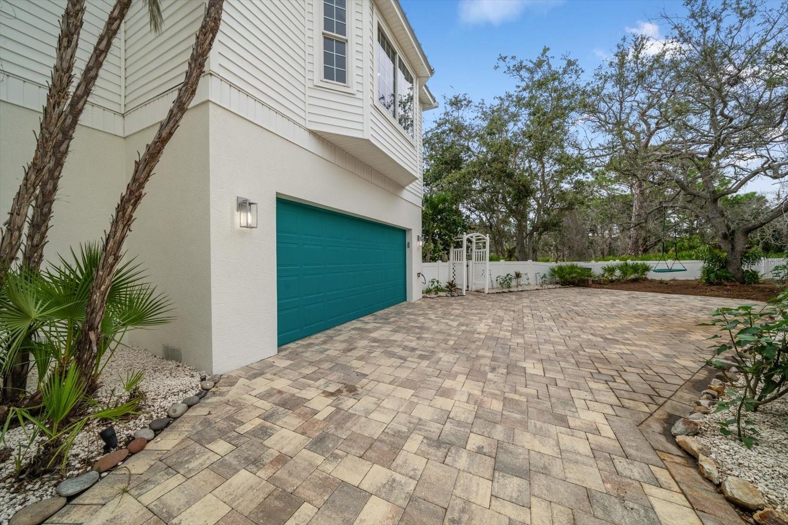 Brick-paved driveway features ample parking space for guests.