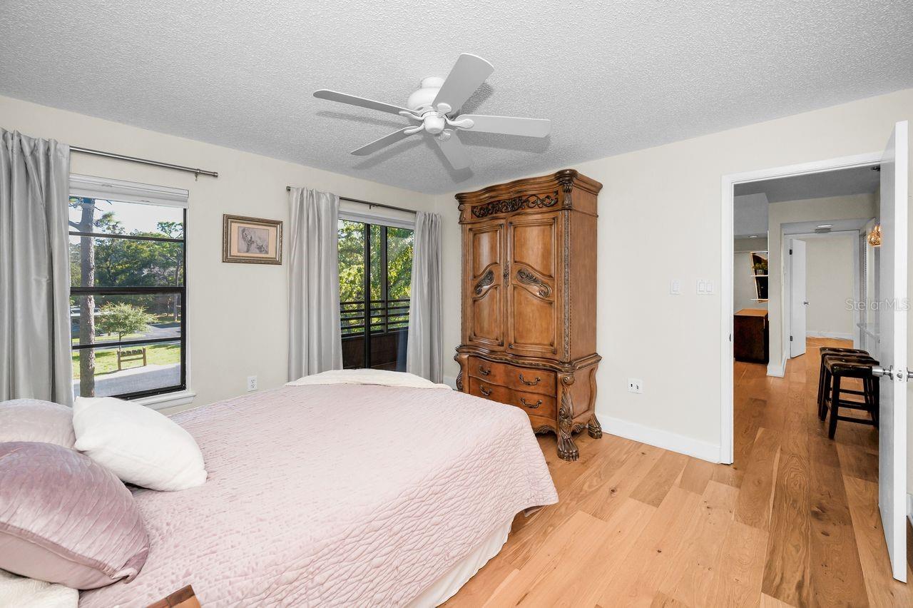 Primary suite offers a beautiful view of the outdoors with sliders that open to screened porch.