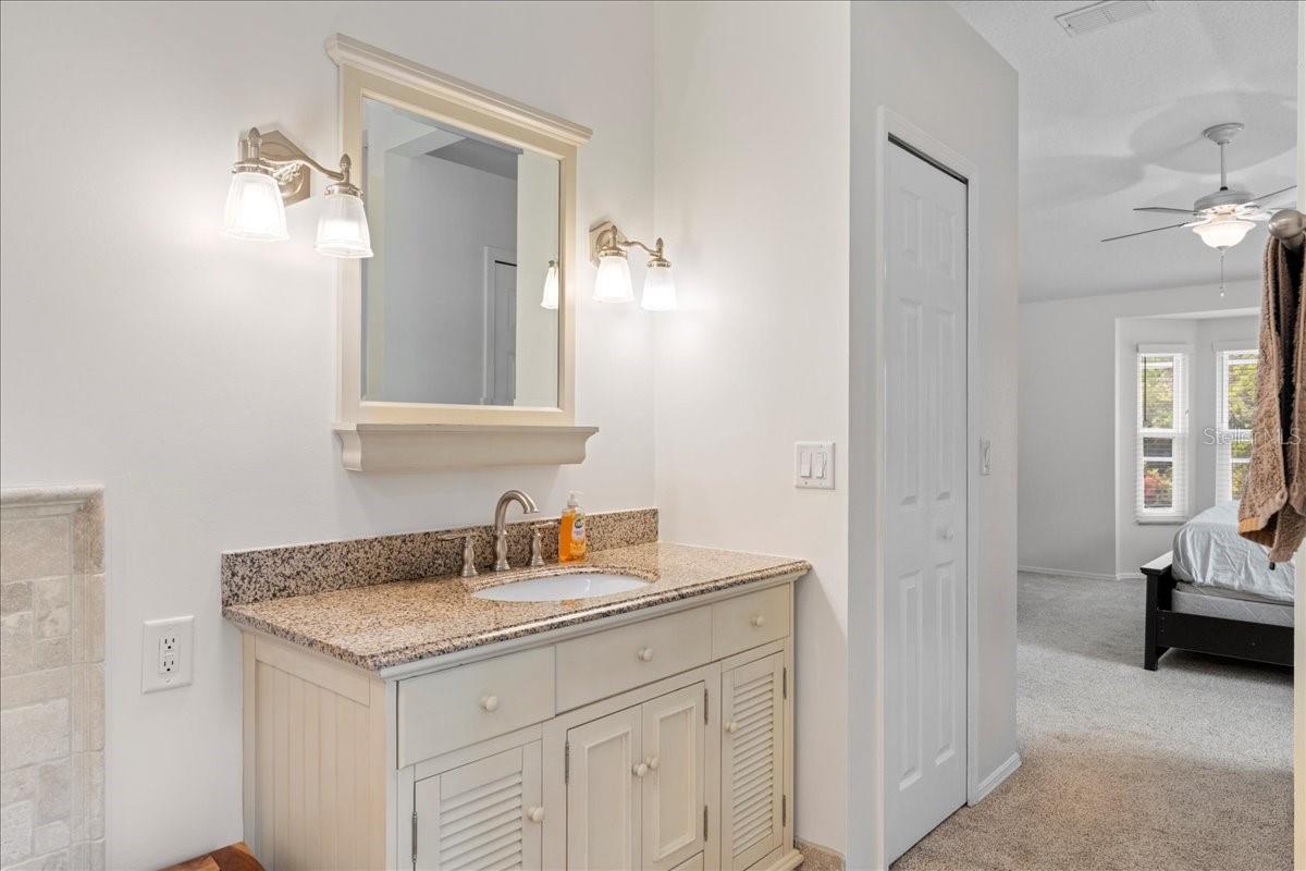 Primary ensuite bathroom featuring a jetted tub, separate Toilet closet, and walk-in shower and spa-like travertine tile accents.