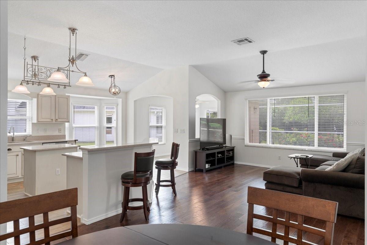 Fantastic open concept living with vaulted ceilings and large windows with views of pool and pond just beyond.