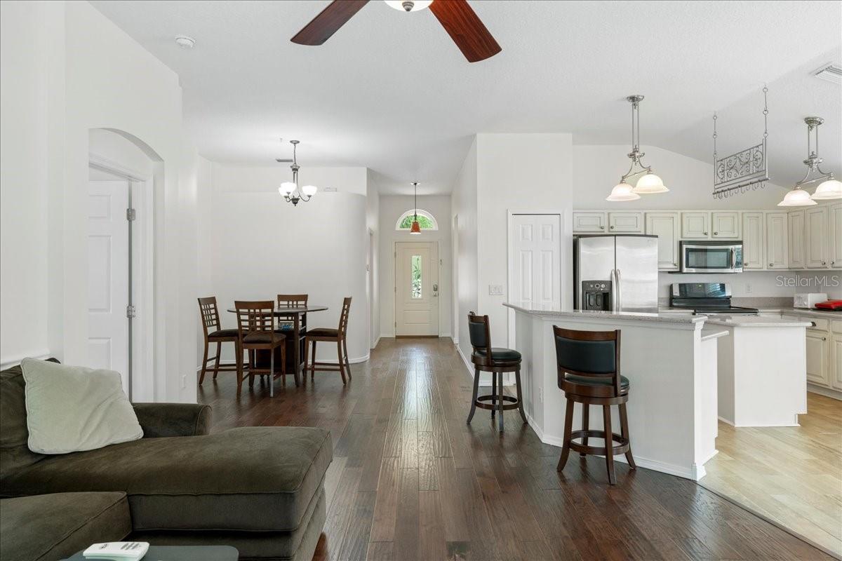 Fantastic open concept living with vaulted ceilings and large windows with views of pool and pond just beyond.