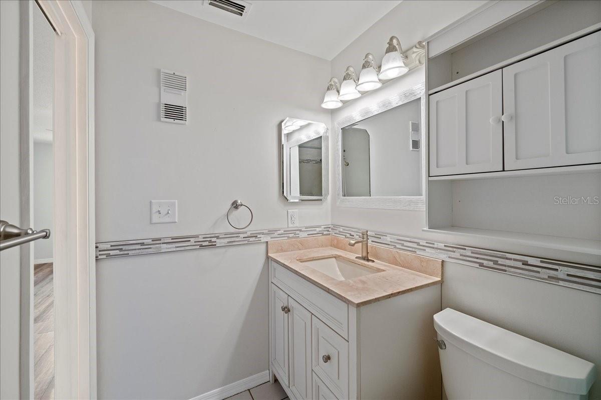Primary bathroom is light and bright and updated with stylish vanity and shower/tub combo