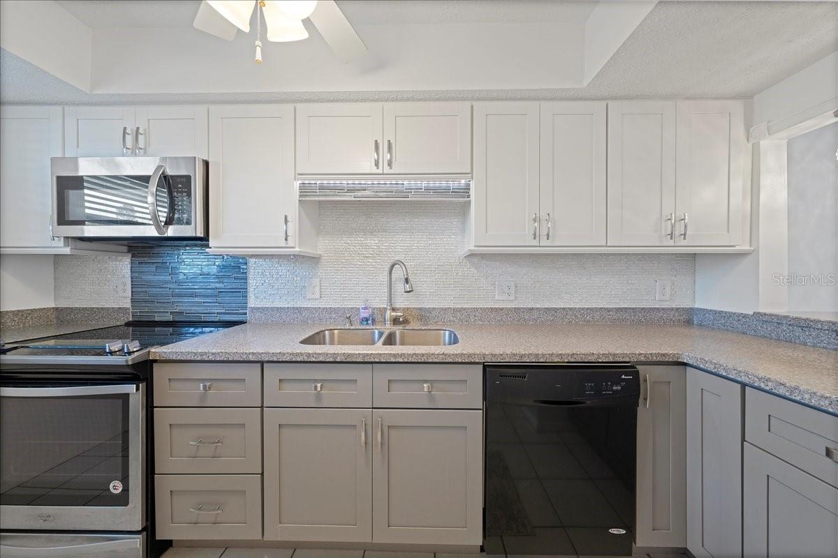 Updated kitchen with neutral colors, Corian countertops, stainless-steel appliances, a stylish backsplash, nice-sized pantry, and a passthrough breakfast bar to the dining room.