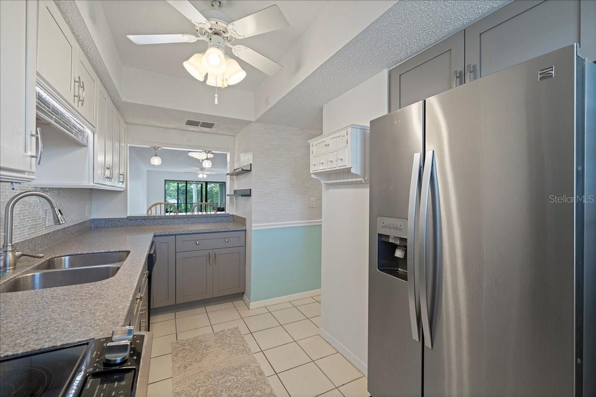 Updated kitchen with neutral colors, Corian countertops, stainless-steel appliances, a stylish backsplash, nice-sized pantry, and a passthrough breakfast bar to the dining room.