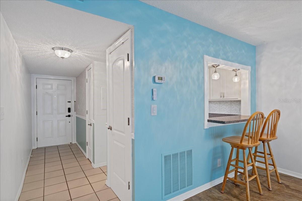 Foyer, two closets, and breakfast bar pass through to the dining room perfect for serving or casual meals.