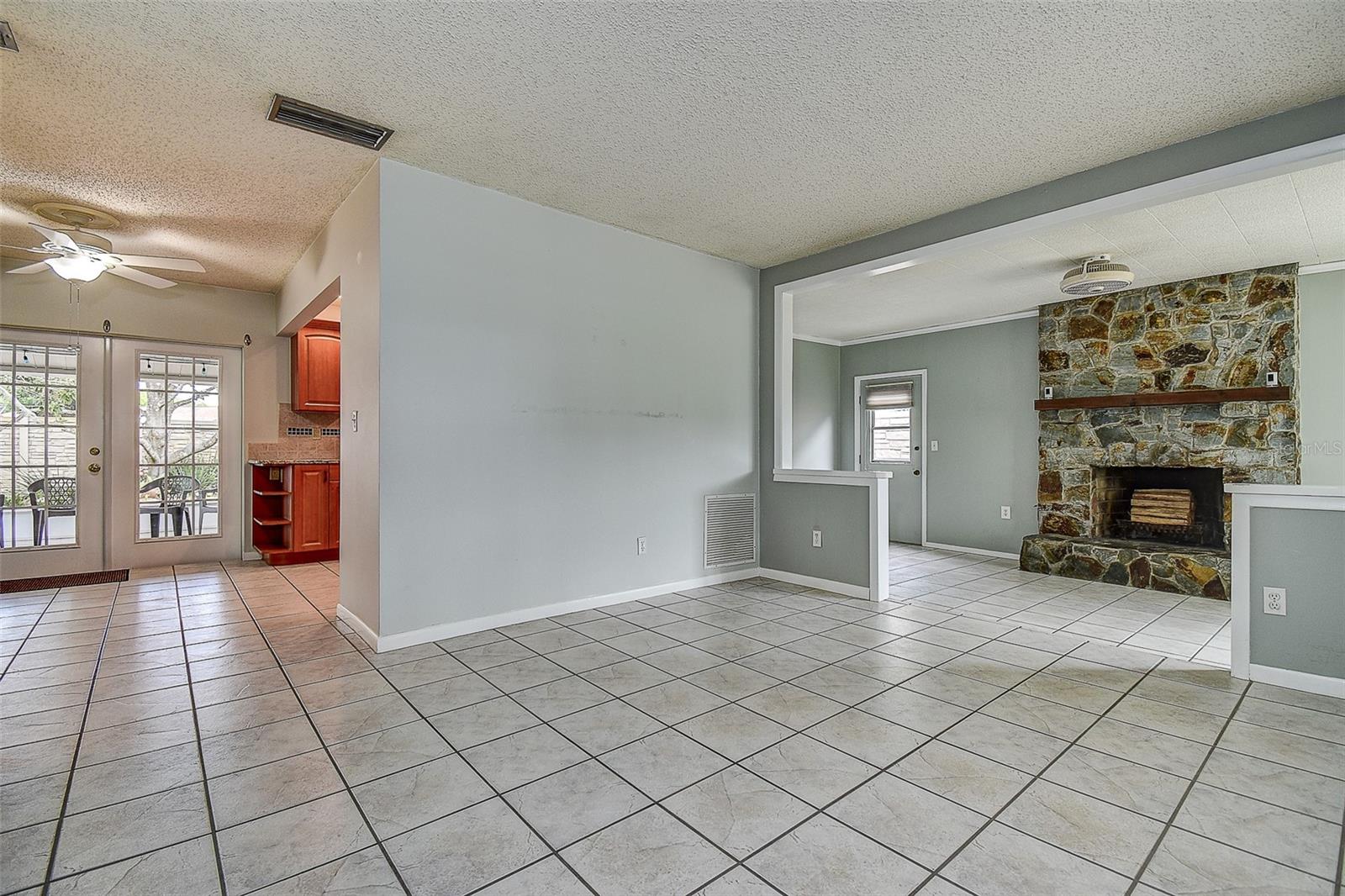 FROM FRONT DOOR TO KITCHEN AND FAMILY ROOM TO THE RIGHT WITH BEAUTIFUL STONE FIREPLACE.
