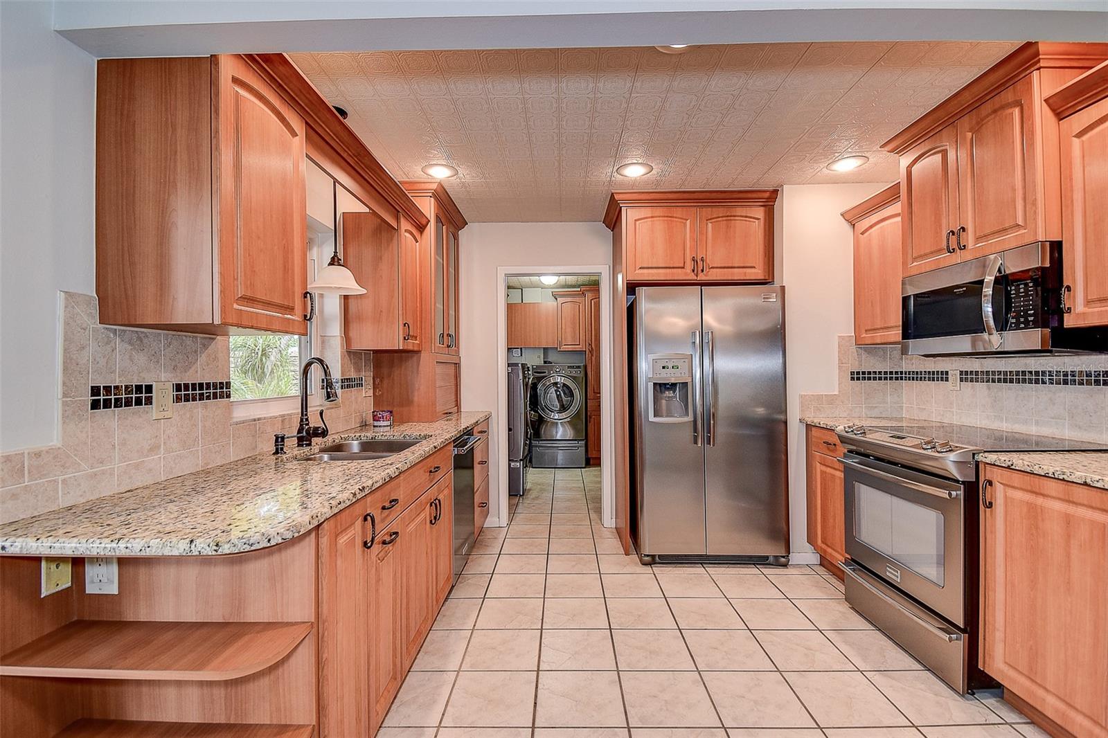 BEAUTIFUL HONEY WOOD CABINETS WITH STYLISH STONE COUNTERS.