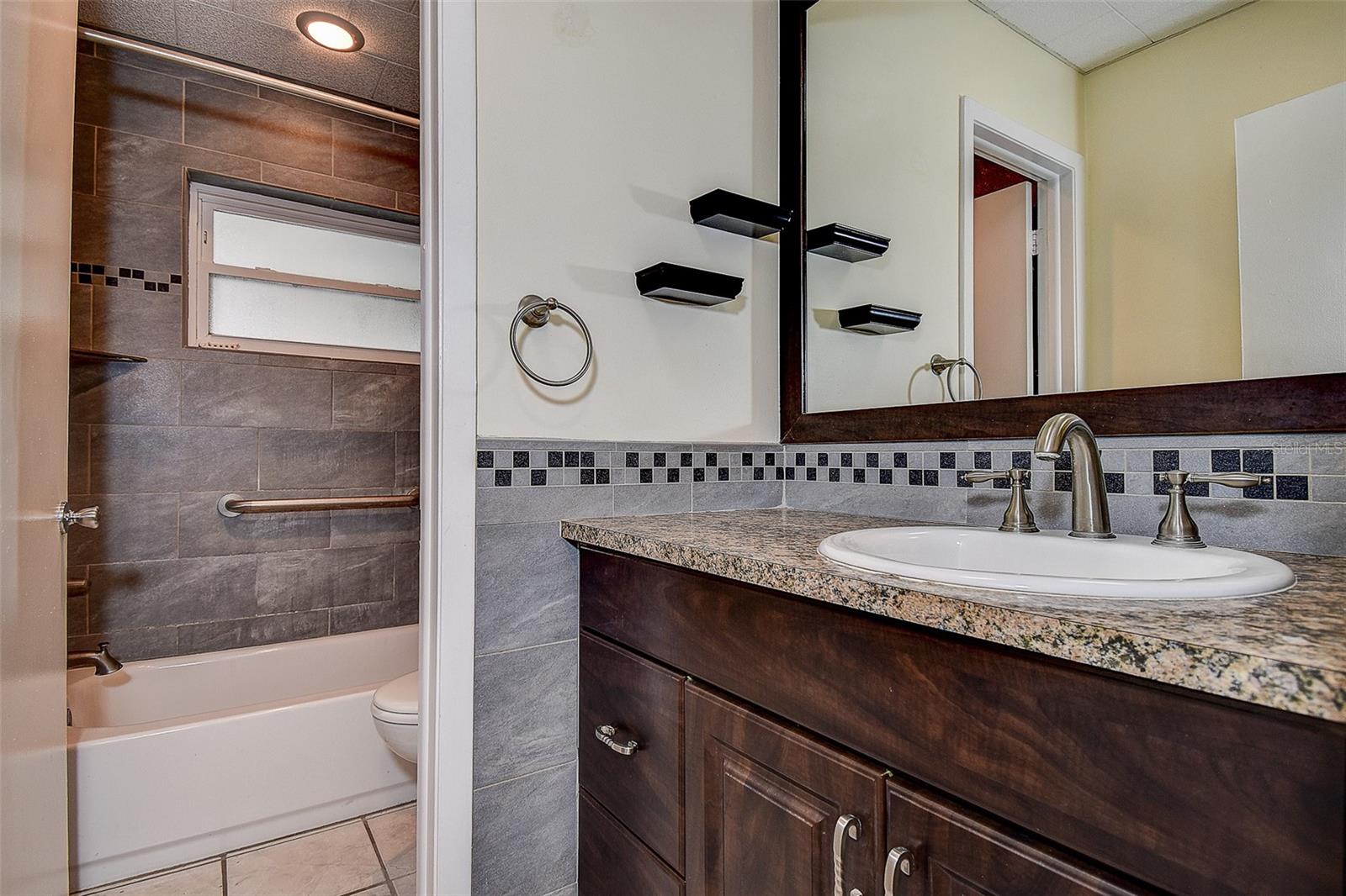 OVERSIZED SPLIT BATHROOM BUILT IN A WAY THAT ALLOWS TWO PEOPLE TO USE THE AREA AT ONCE.