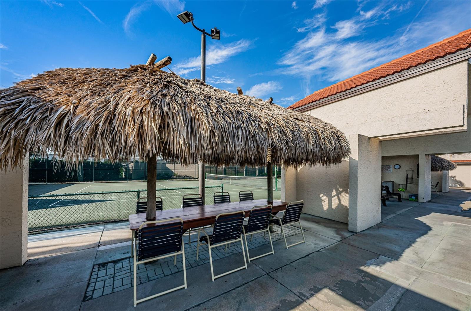 Enjoy the tennis matches while relaxing under a tiki hut