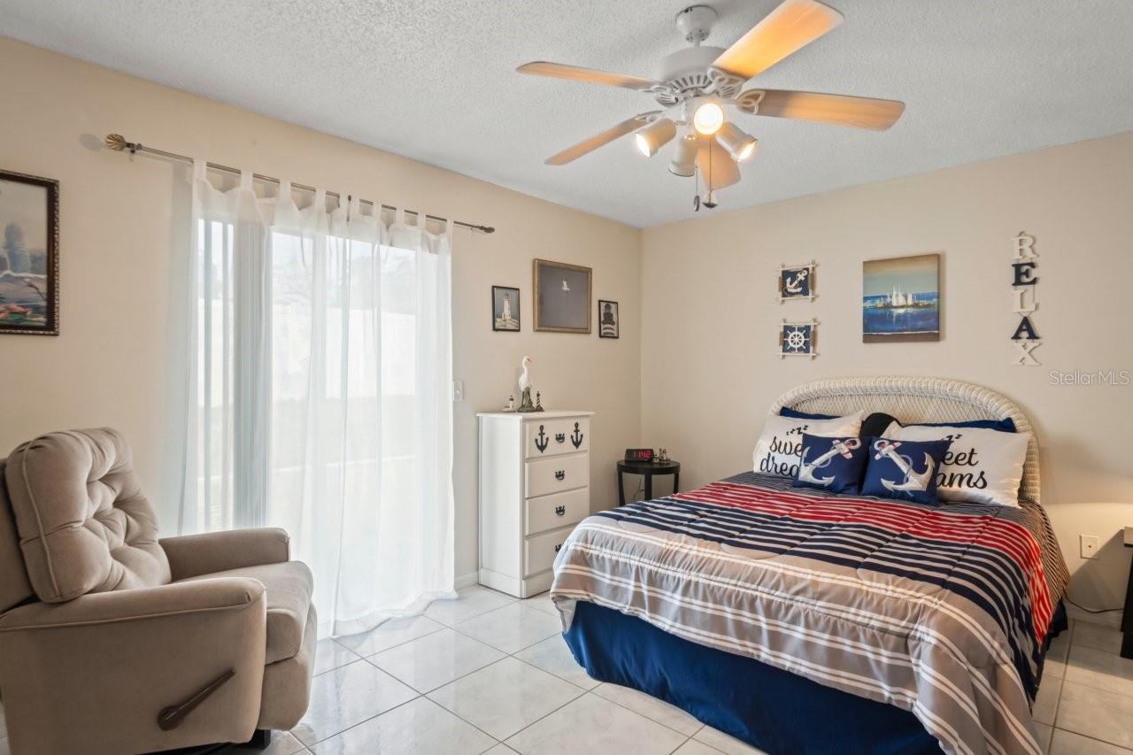Primary bedroom suite has sliders leading to back yard