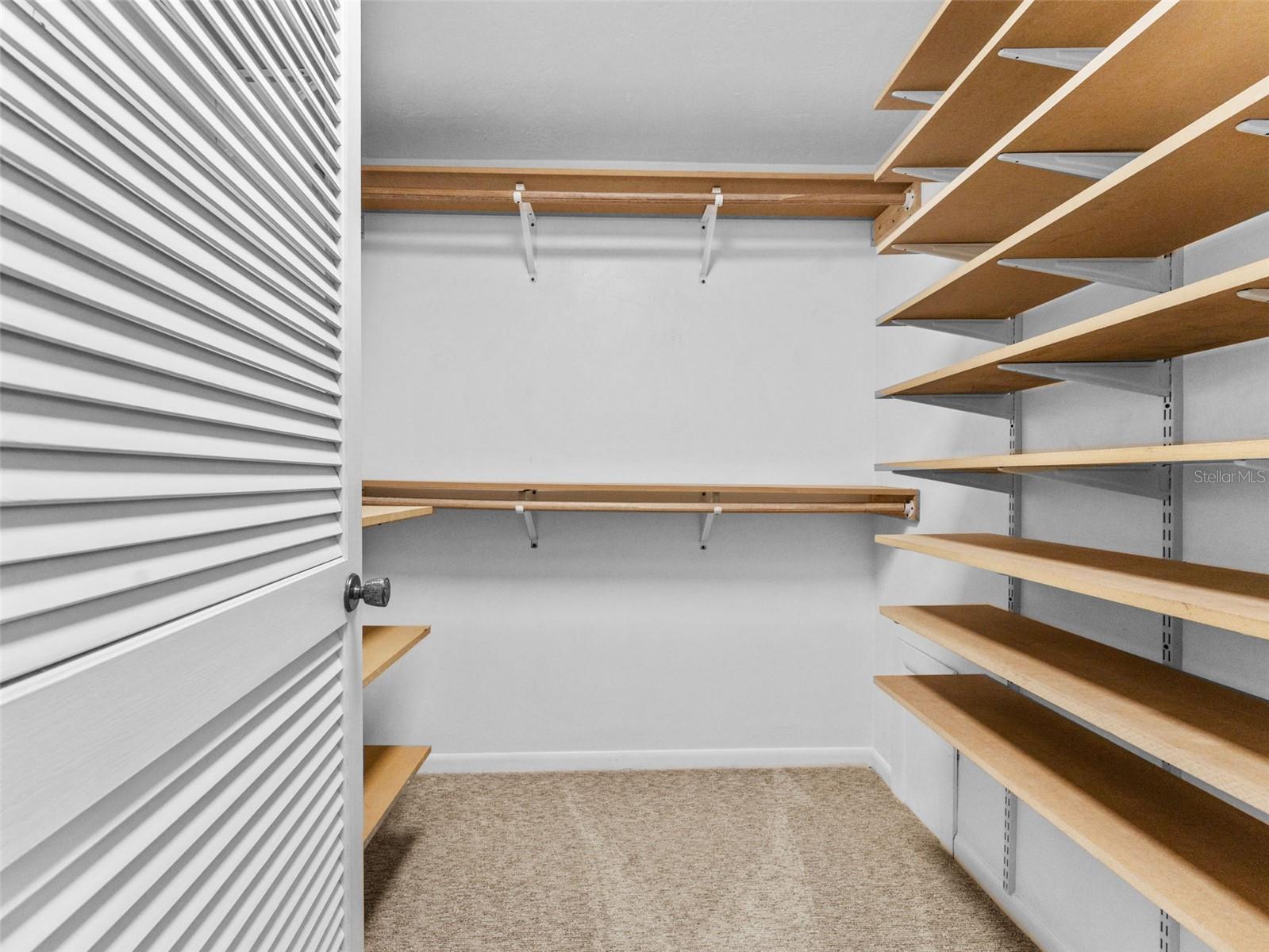 Generous walk-in closet with built-in shelving for effortless organization