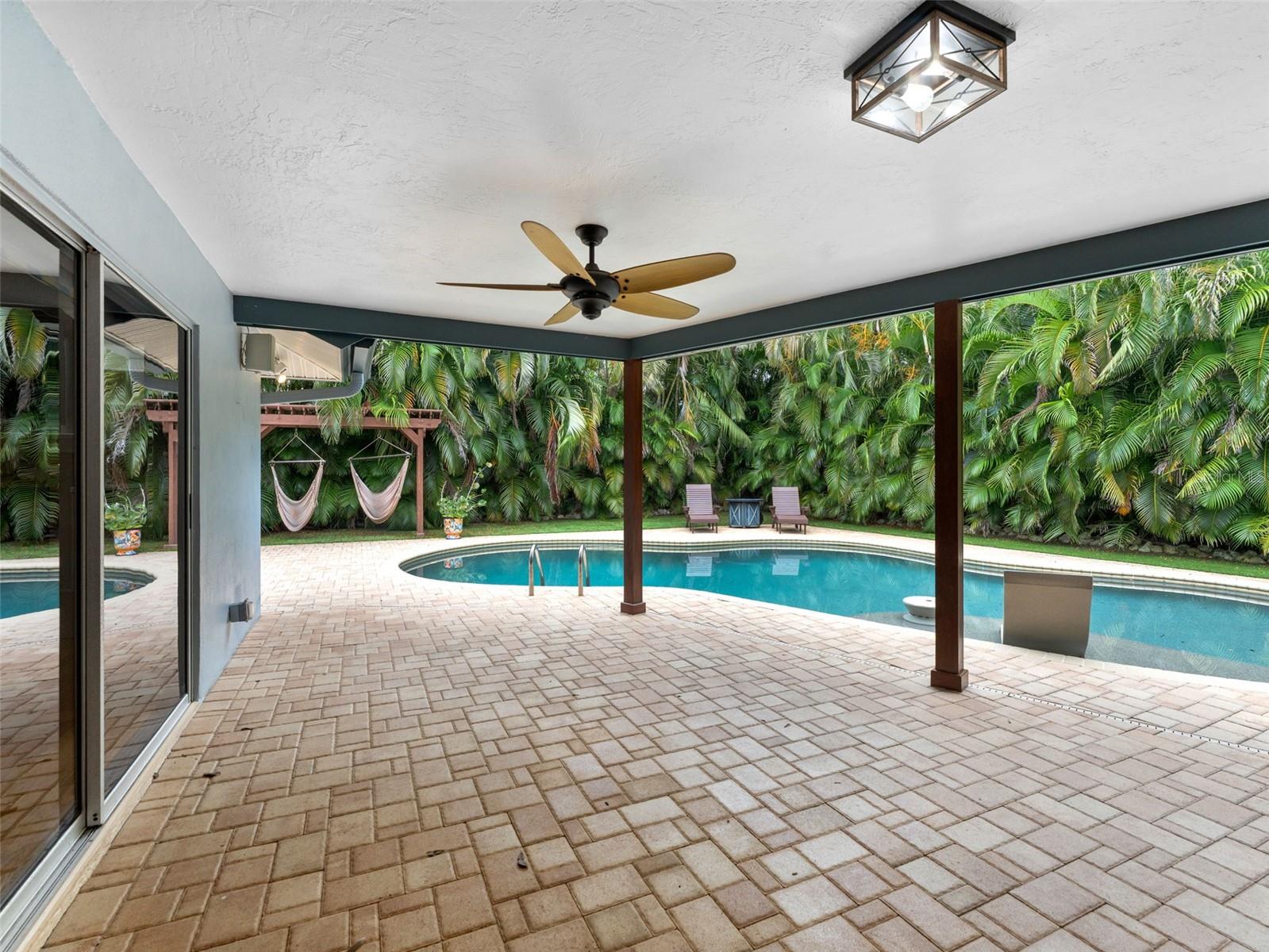 A relaxing covered patio designed for year-round enjoyment by the pool