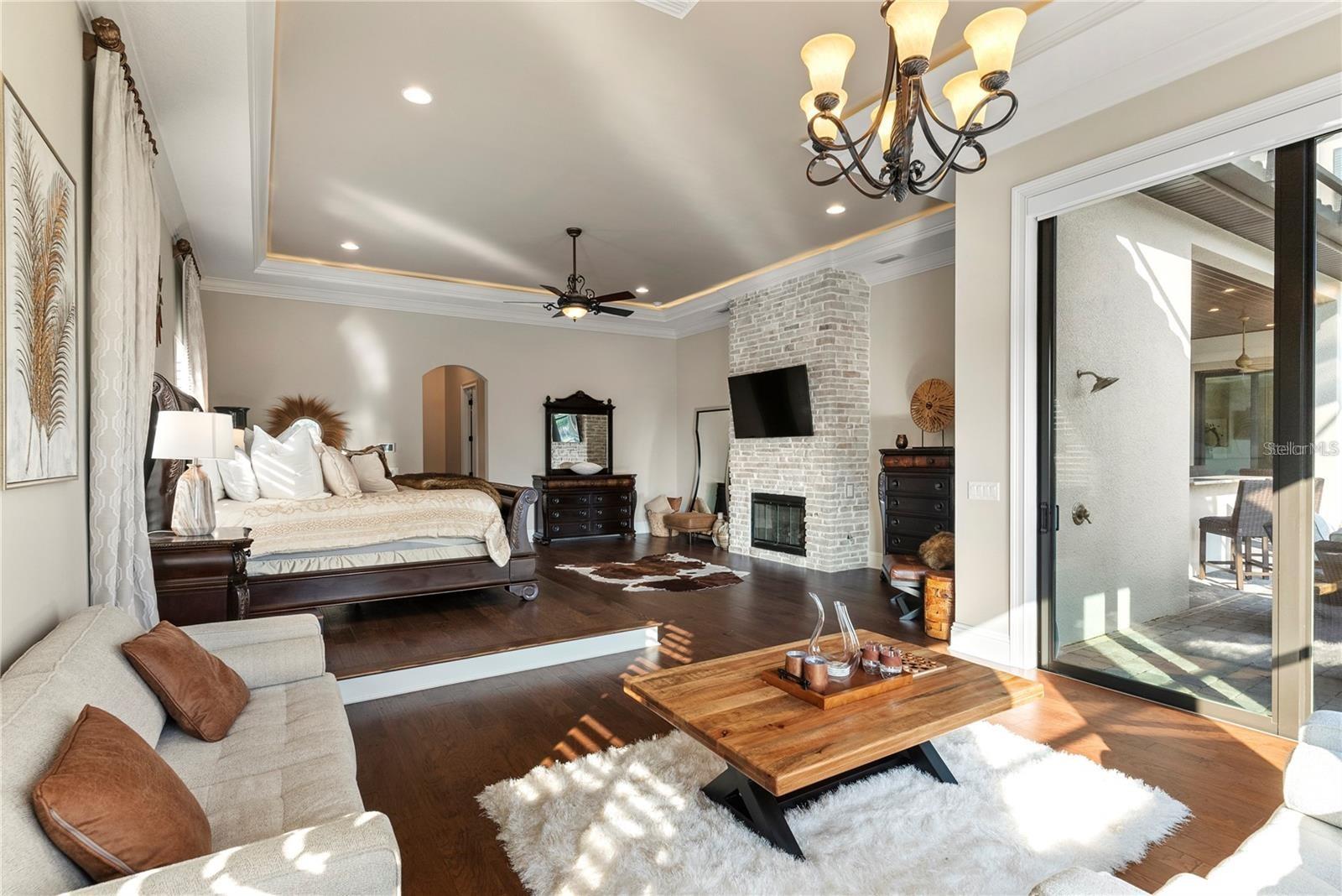 This owner's sanctuary showcases exquisite wood floors and illuminated tray ceilings, seamlessly blending luxury and tranquility.