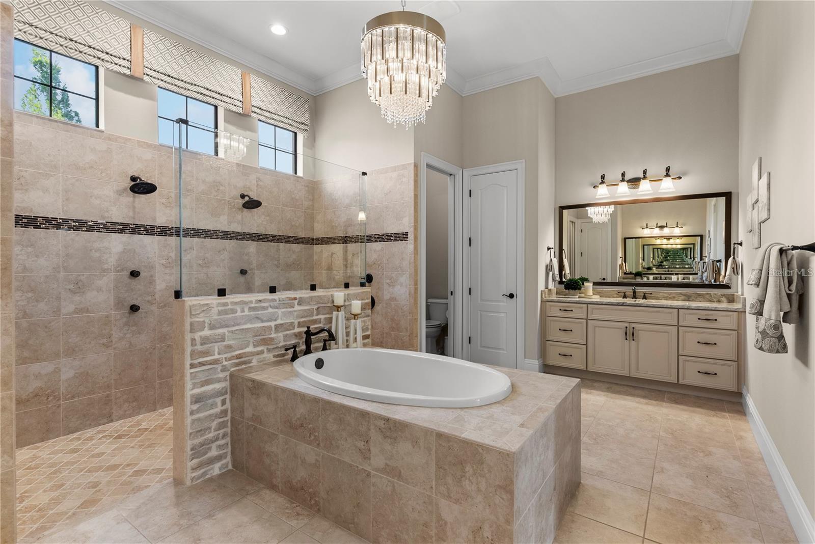 A spa-like drop-in garden tub is perfectly positioned under transom windows, allowing natural light to fill the space.