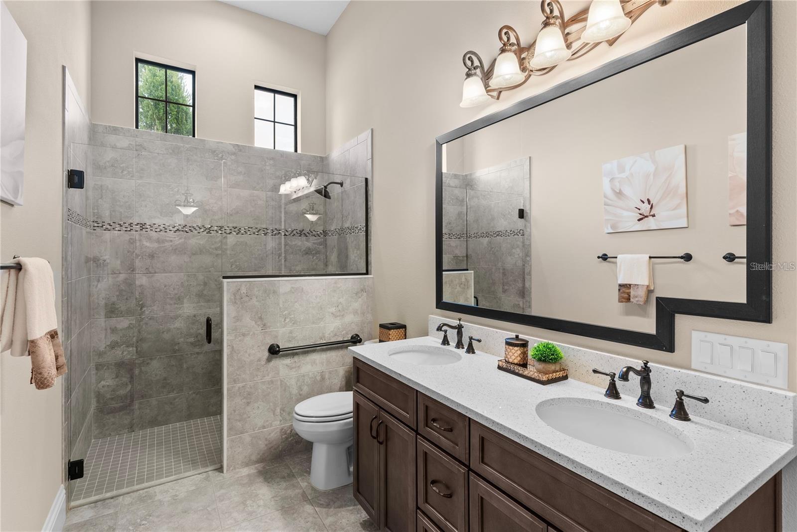 This beautifully designed bathroom features pocket doors for added privacy, and a seamless blend of modern finishes and thoughtful details.