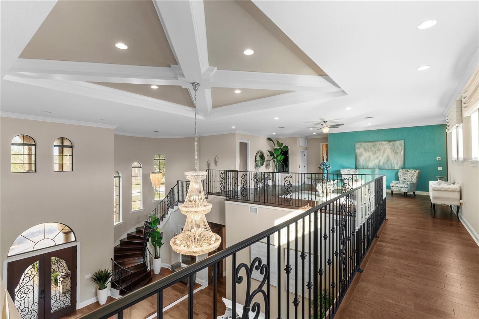 Second-floor breezeway connecting three additional bedroom suites, a cozy theater room, and an extra bedroom, creating an ideal space for guests.