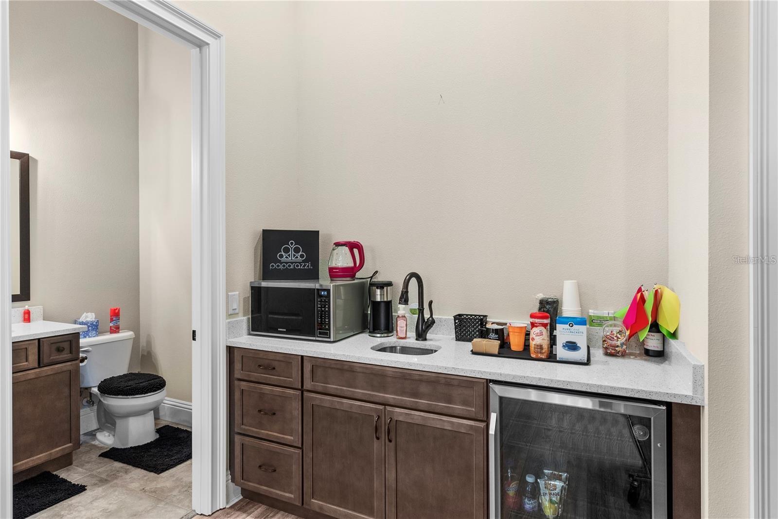 This versatile space offers a wet bar with sink and mini fridge.