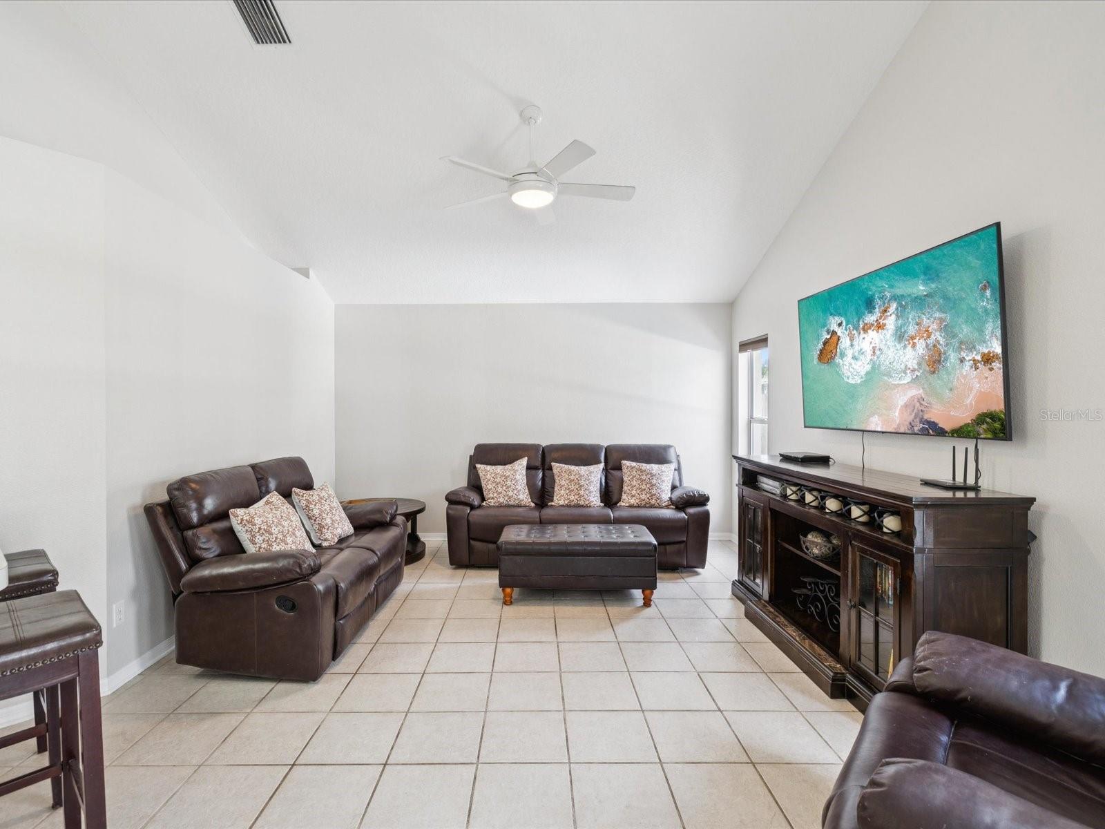 The great room is light and airy with it's vaulted ceiling and lots of natural light from the surrounding windows.