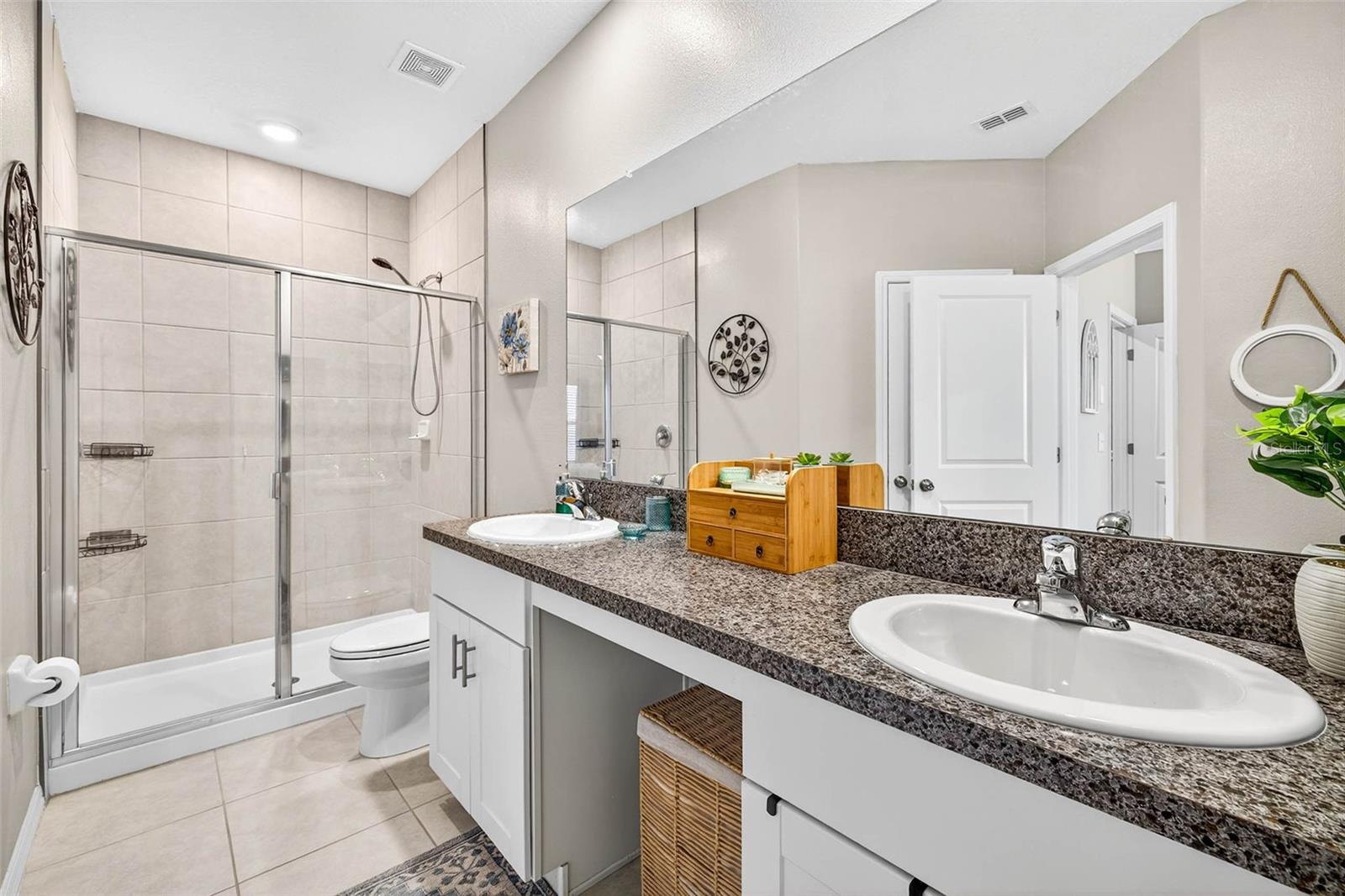 Ensuite bath with walk in shower, dual sinks + vanity area & linen closet.