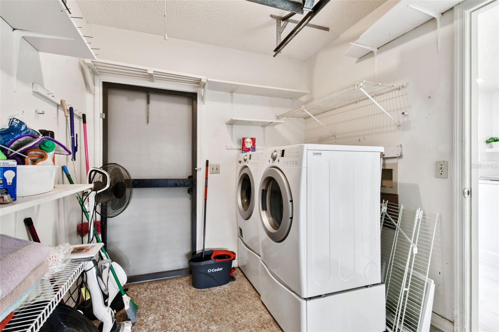 large utility room off the kitchen with that is also part of the garage that has a door to the outside as well as an extra door to the garage. Loads of storage!