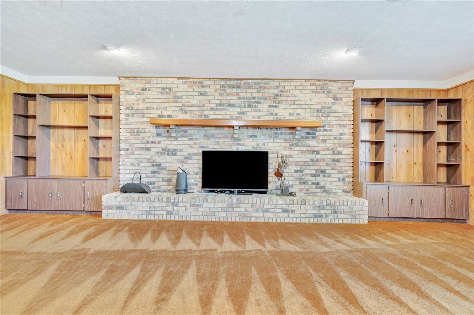 Inviting fireplace with wood shelving—perfect for relaxing evenings