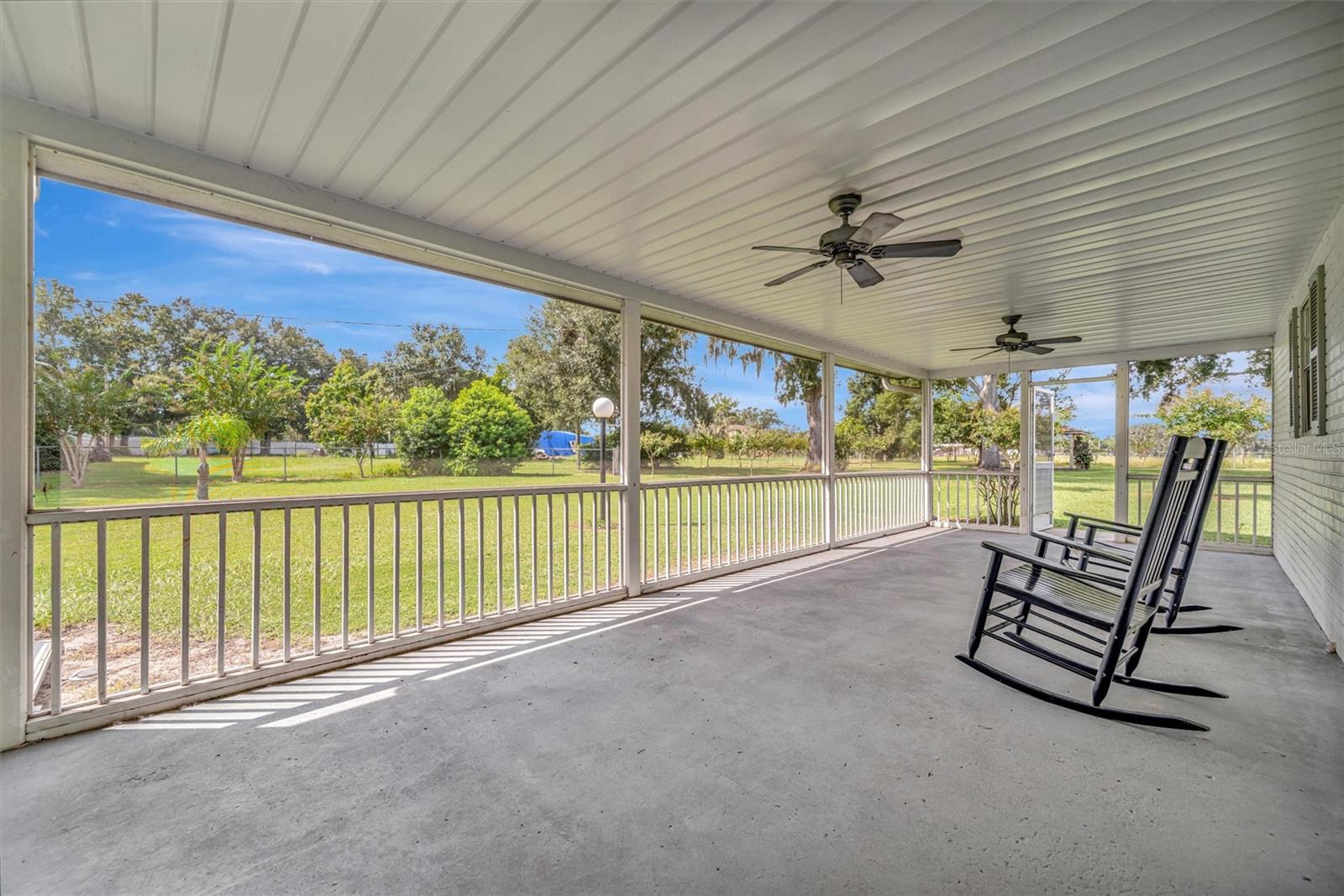 Large screened porch offering serene views of country living