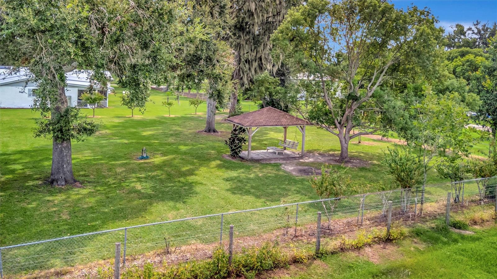 Gazebo nestled in the spacious backyard, surrounded by open land.