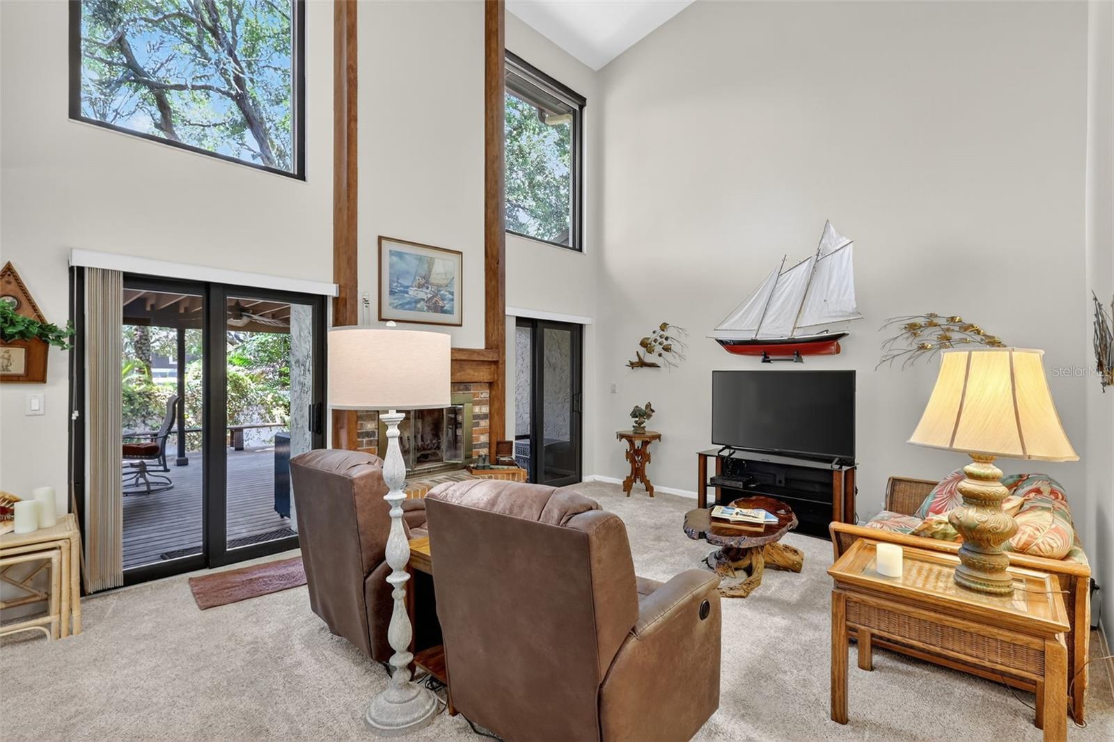 As you enter the Living area you will see expansive windows for light and 2 sliders  leading out to the back covered deck area.