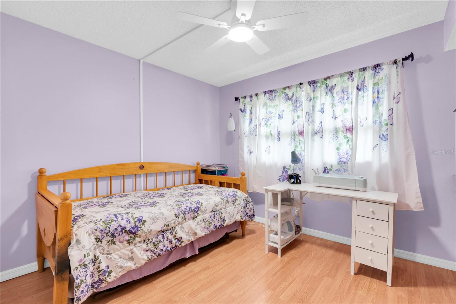 Second bedroom with natural light, ceiling fan, and closet